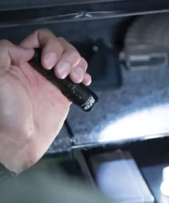 Šaulys laiko rankoje įjungtą Smith & Wesson CS-10 žibintuvėlį – realus dydžio pavyzdys.